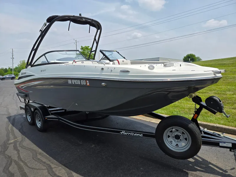 Slide: The Image of 2021 Hurricane SunDeck 217 OB boat on trailer, parked on a paved road. - 5
