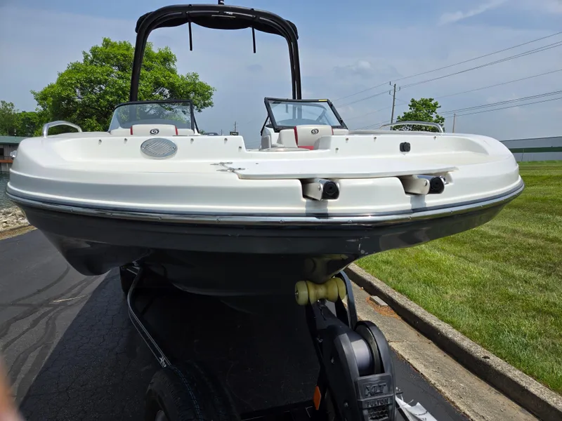Slide: The Image of 2021 Hurricane SunDeck 217 OB boat on trailer, parked on a paved road. - 6