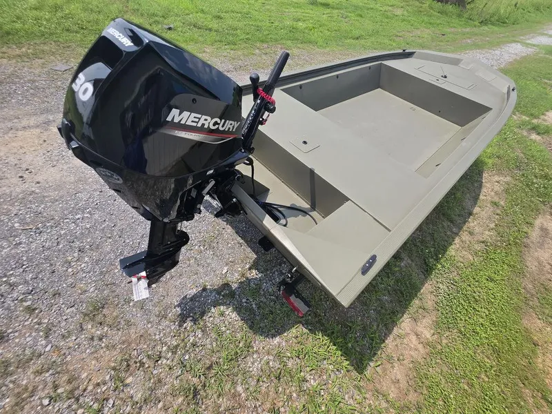 Slide: The Image of 2025 Tracker Grizzly 1648 Utility boat with Mercury outboard motor on grassy terrain. - 9