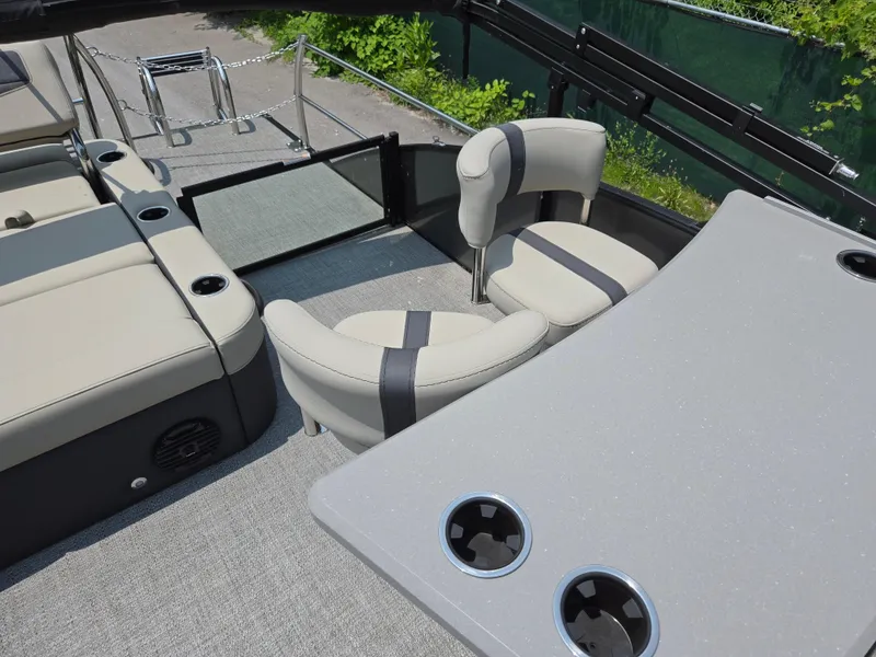 Slide: The Image of 2023 Barletta Cabrio 24UE boat interior with seating and table, featuring cup holders. - 16