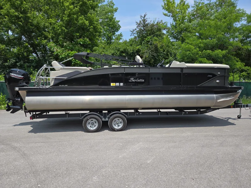 Slide: The Image of 2023 Barletta Cabrio 24UE pontoon boat on trailer, parked outdoors. - 4