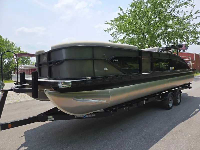 Slide: The Image of 2023 Barletta Cabrio 24UE pontoon boat on trailer, parked outdoors. - 9