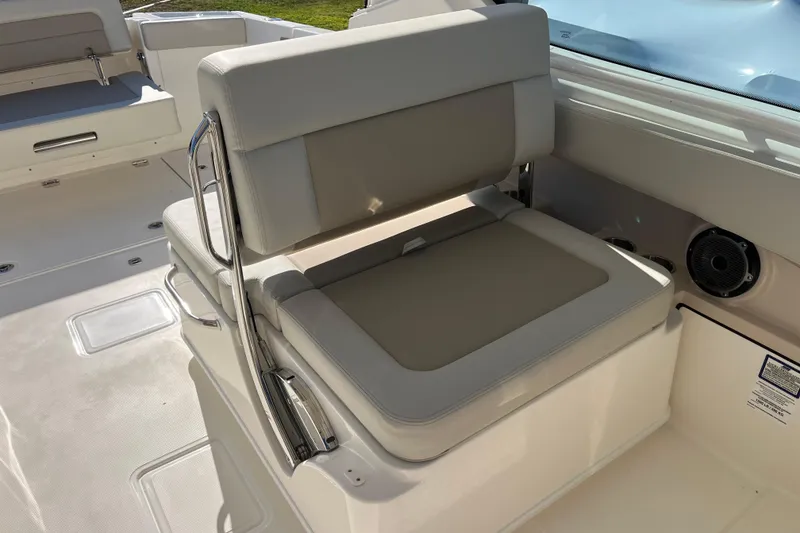 Slide: The Image of 2026 Boston Whaler 280 Vantage boat interior seating with beige cushions and stainless steel accents. - 19