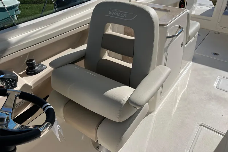 Slide: The Image of Captain's seat on 2026 Boston Whaler 280 Vantage boat, featuring modern controls and steering wheel. - 25
