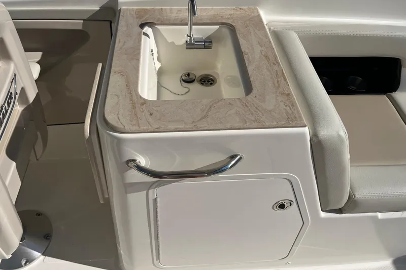 Slide: The Image of 2026 Boston Whaler 280 Vantage boat sink with marble countertop and storage. - 27