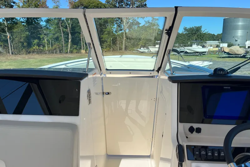 Slide: The Image of 2026 Boston Whaler 280 Vantage cockpit with open windshield, showcasing control panel and outdoor view. - 30