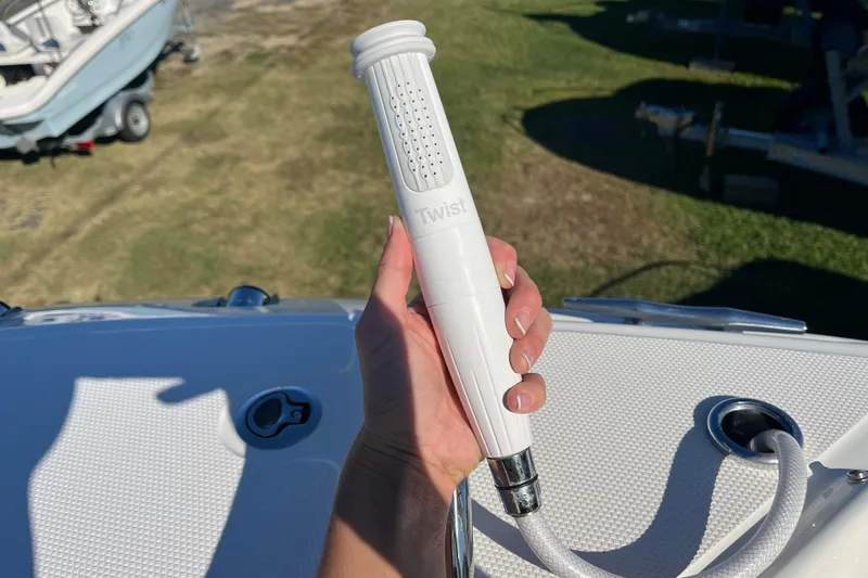 Slide: The Image of Hand holding a white hose nozzle on a 2026 Boston Whaler 280 Vantage boat. - 9