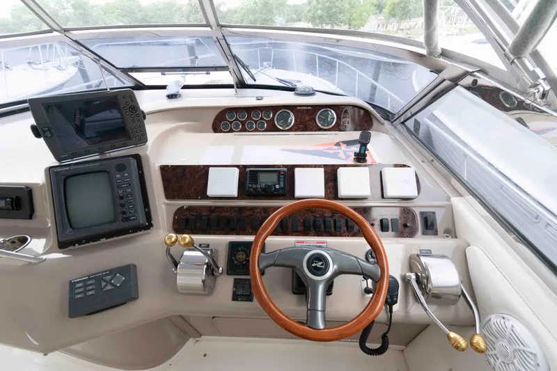 Slide: The Image of Cockpit of 1998 Sea Ray 450 Sundancer with steering wheel and navigation equipment. - 10