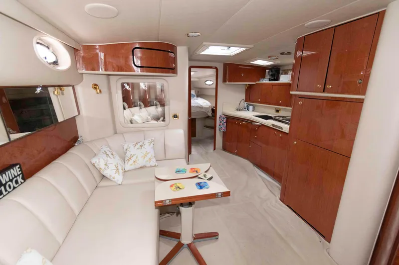 Slide: The Image of Interior of 1998 Sea Ray 450 Sundancer yacht with elegant wood cabinetry and cozy seating area. - 12