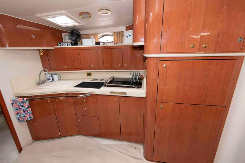Slide: The Image of Interior of 1998 Sea Ray 450 Sundancer yacht kitchen with wooden cabinets and modern appliances. - 14