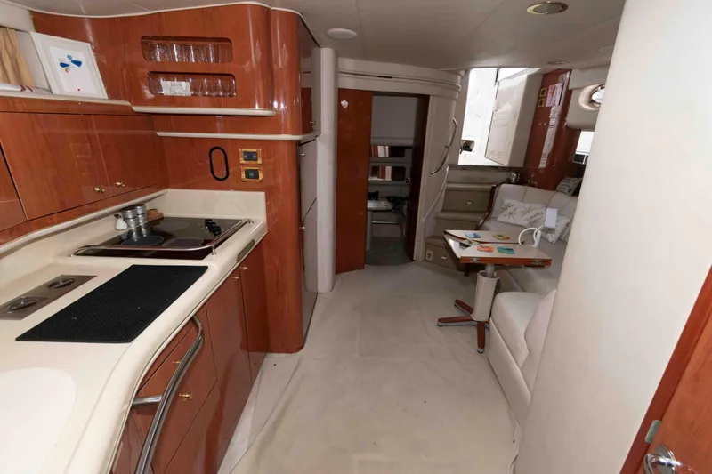 Slide: The Image of Interior of 1998 Sea Ray 450 Sundancer yacht with kitchen and seating area. - 15