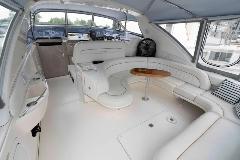 Slide: The Image of Luxurious interior of 1998 Sea Ray 450 Sundancer yacht with white seating and wooden table. - 7