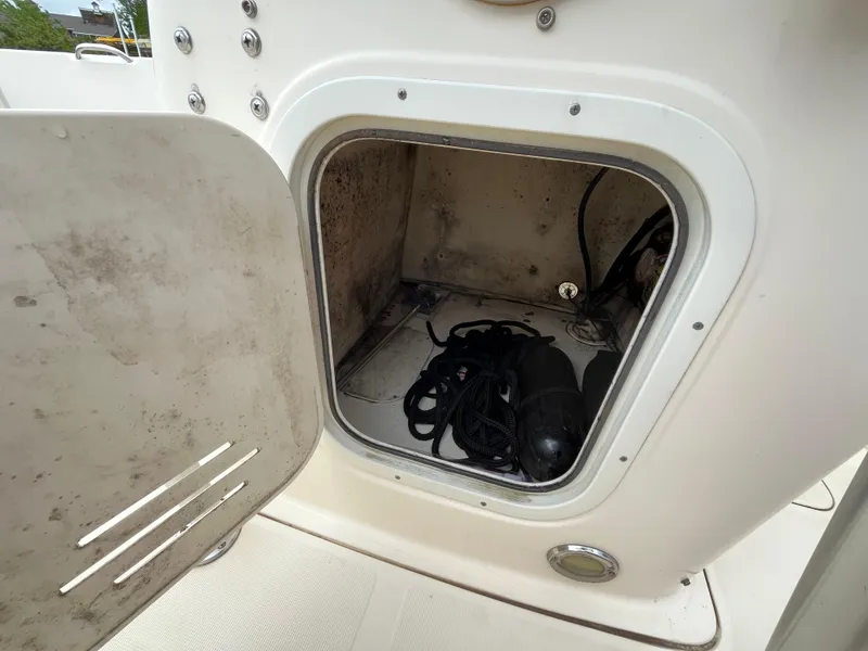Slide: The Image of Open storage compartment on 2014 Scout 195 Sportfish boat, containing ropes and equipment. - 14