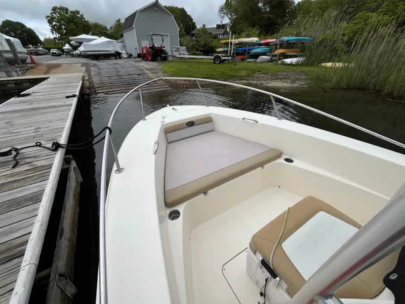 Slide: The Image of 2014 Scout 195 Sportfish boat docked, featuring spacious seating and sleek design. - 15