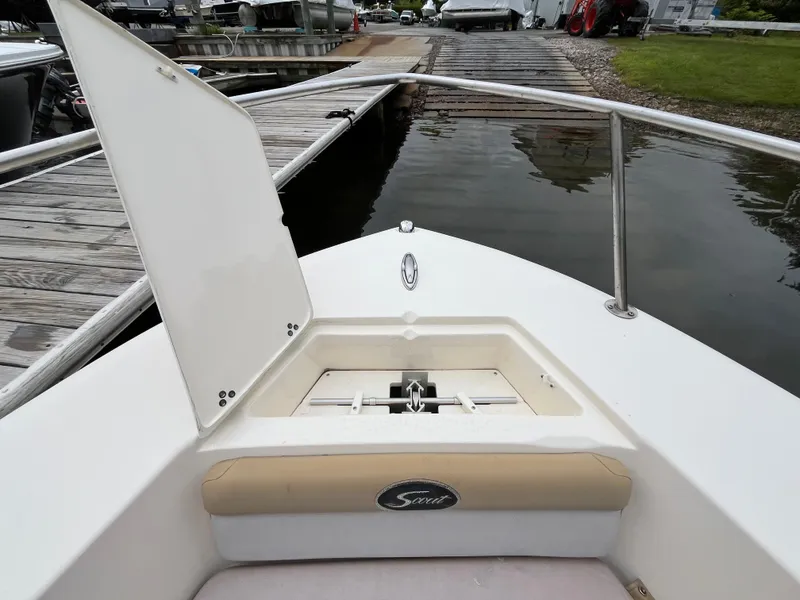 Slide: The Image of 2014 Scout 195 Sportfish boat bow with open storage compartment at dock. - 20