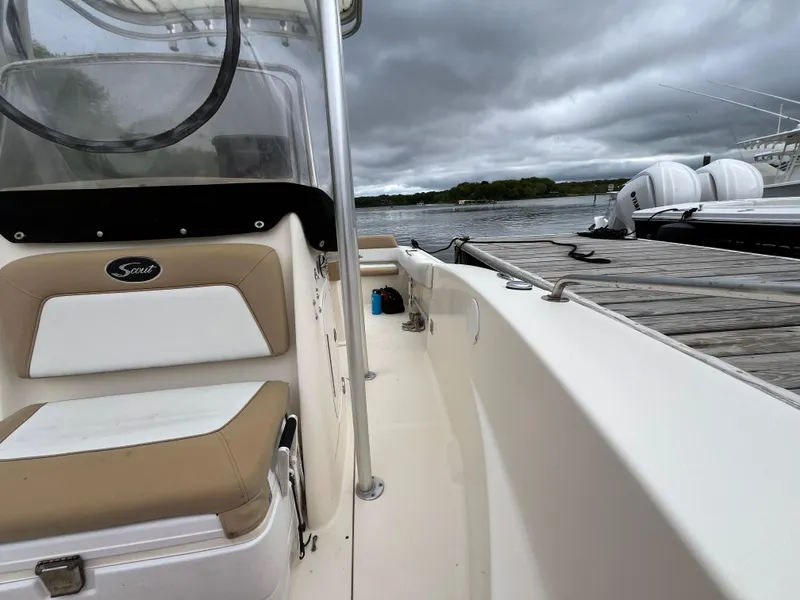 Slide: The Image of 2014 Scout 195 Sportfish boat docked by a wooden pier under cloudy skies. - 24