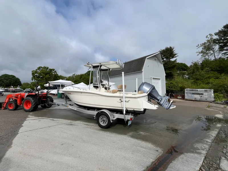 Slide: The Image of 2014 Scout 195 Sportfish boat on trailer near barn, with tractor nearby. - 3