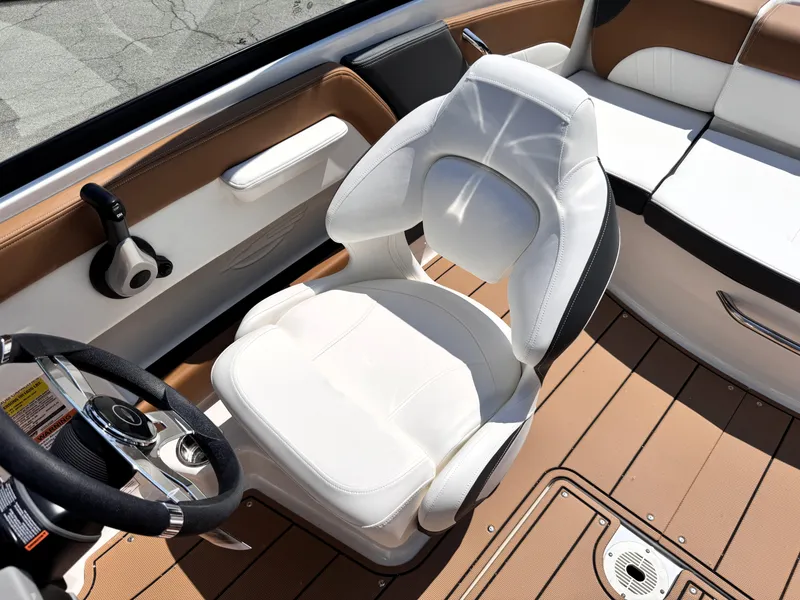 Slide: The Image of 2025 Chaparral 21 SSi OB boat interior with white captain's chair and steering wheel. - 10