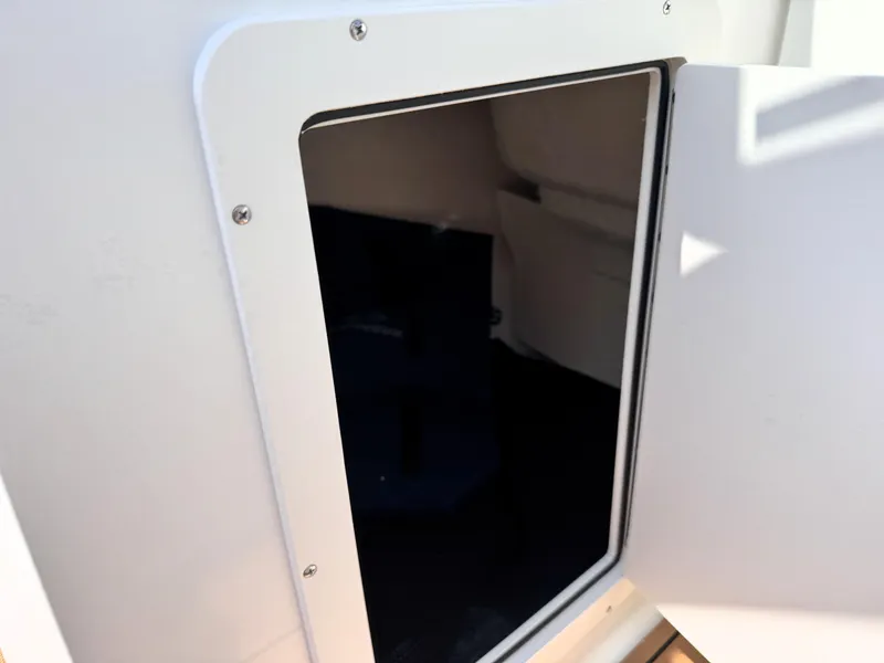 Slide: The Image of 2025 Chaparral 21 SSi OB boat storage compartment with open door. - 19