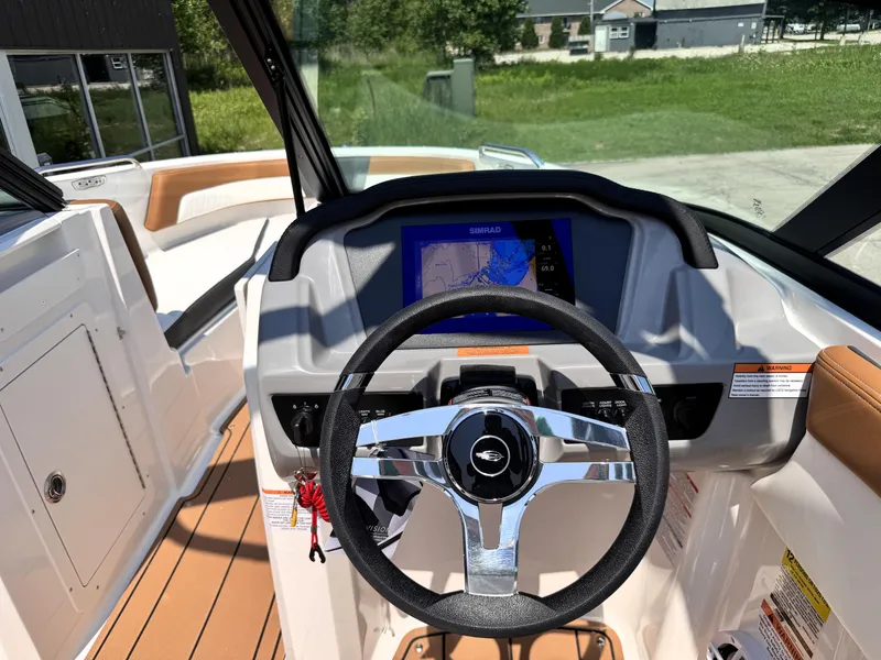Slide: The Image of 2025 Chaparral 21 SSi OB boat dashboard with steering wheel and navigation display. - 23
