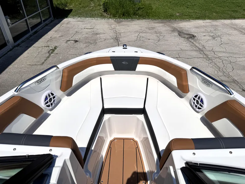 Slide: The Image of 2025 Chaparral 21 SSi OB boat interior with brown and white seating, outdoor setting. - 26