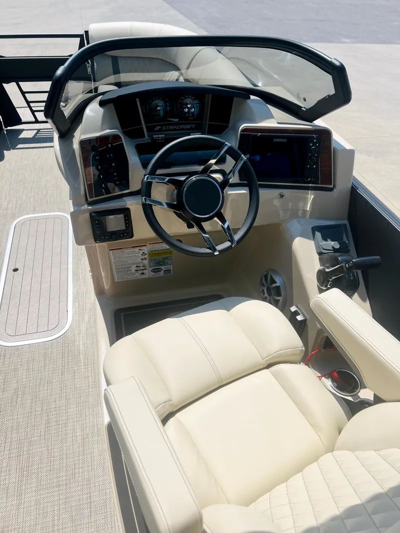 Slide: The Image of Luxurious seating on 2026 Starcraft RX 23 R DC boat, featuring beige upholstery and speaker system. - 12