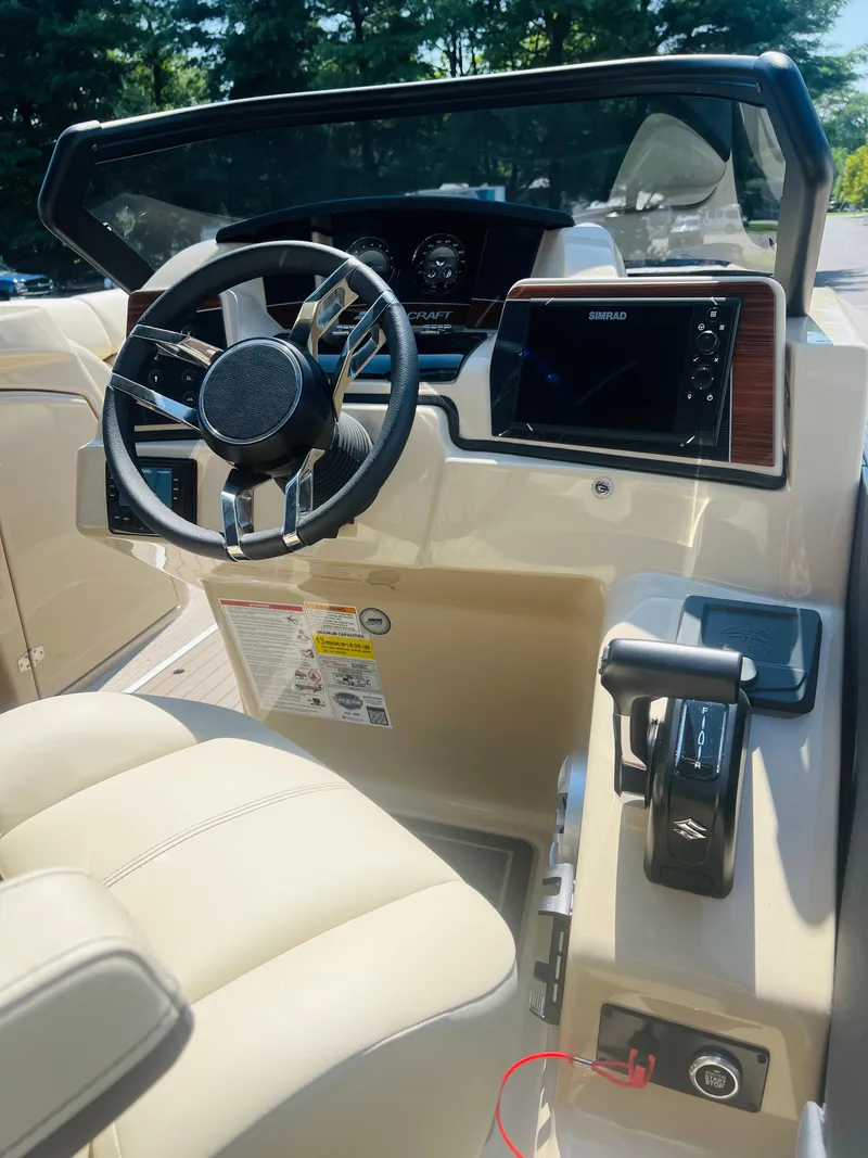 Slide: The Image of 2026 Starcraft RX 23 R DC boat dashboard with steering wheel and control panel. - 13