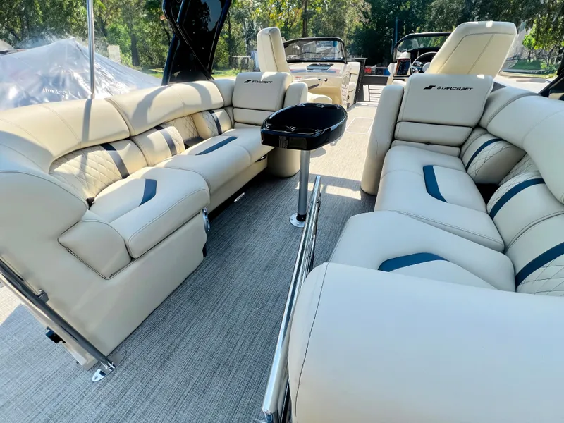 Slide: The Image of 2026 Starcraft RX 23 R DC boat on trailer, sleek black design, parked outside a blue building. - 4