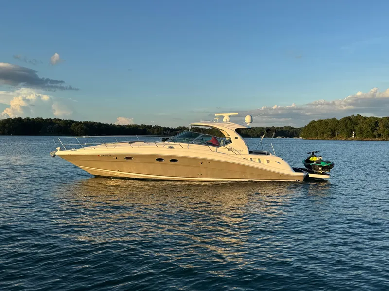 The Image of 2005 Sea Ray 420 Sundancer yacht cruising on a serene lake at sunset. - 0
