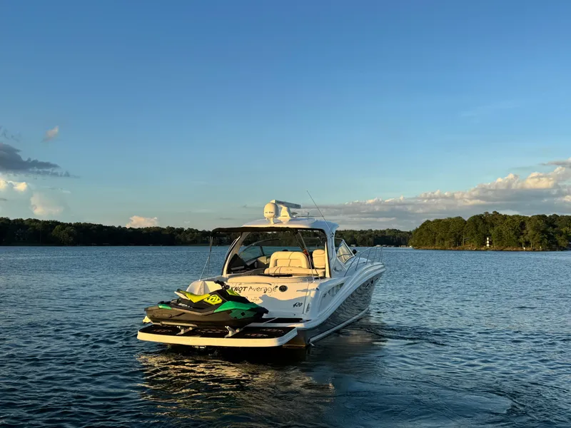 Slide: The Image of 2005 Sea Ray 420 Sundancer yacht on a serene lake at sunset. - 14