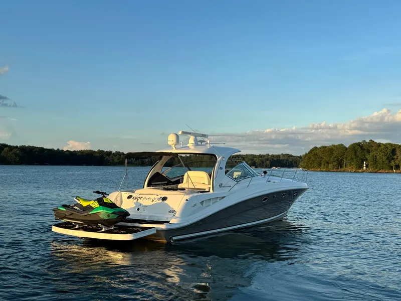 Slide: The Image of 2005 Sea Ray 420 Sundancer yacht on a serene lake with jet ski. - 16