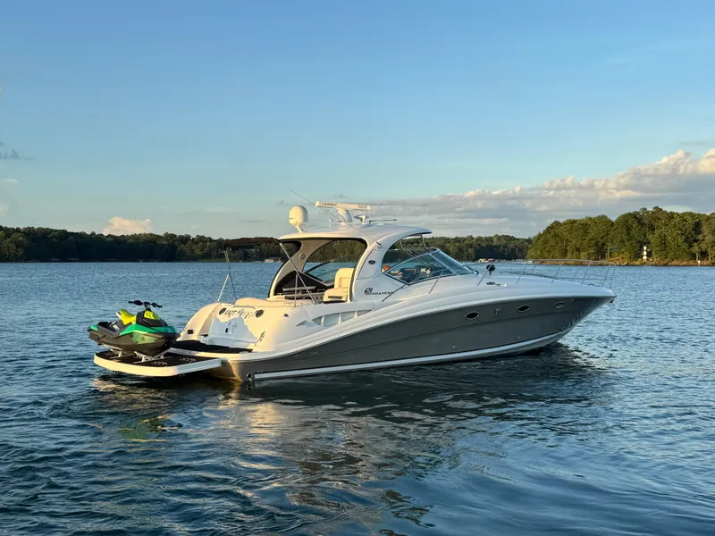 Slide: The Image of 2005 Sea Ray 420 Sundancer yacht with jet ski on calm water at sunset. - 17