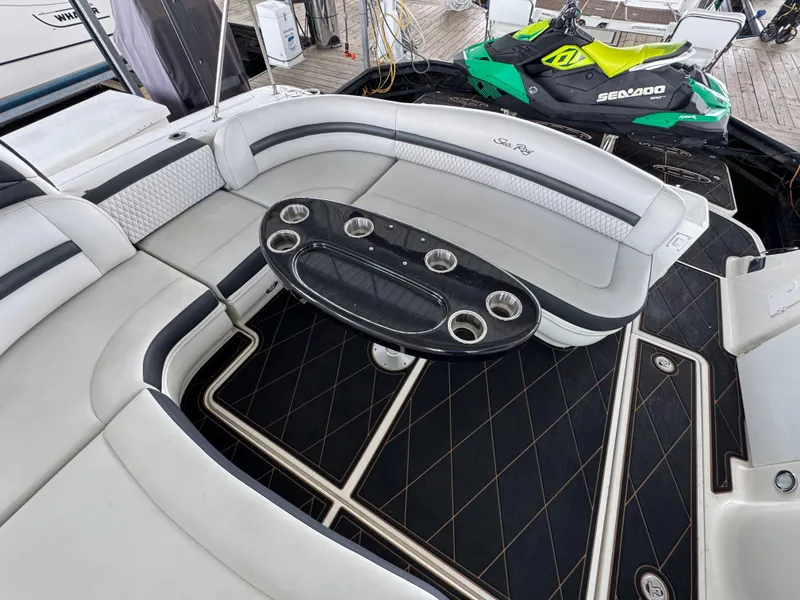 Slide: The Image of 2005 Sea Ray 420 Sundancer yacht interior with seating and table, docked with Sea-Doo jet ski. - 26