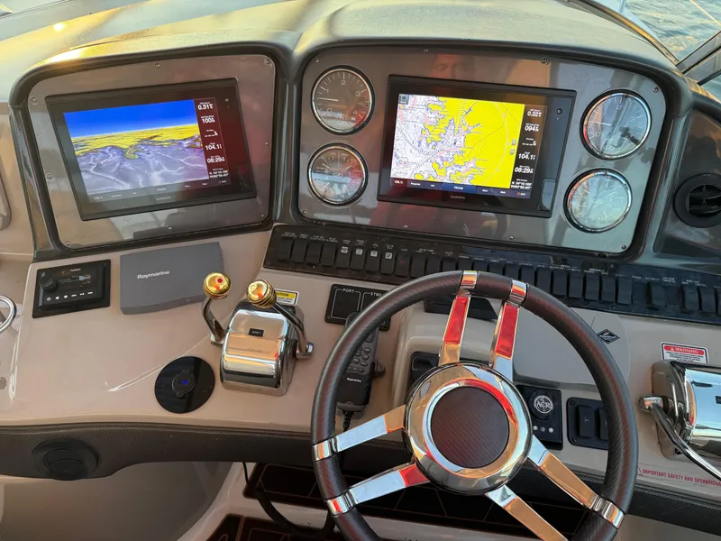 Slide: The Image of Dashboard of a 2005 Sea Ray 420 Sundancer with navigation screens and controls. - 29
