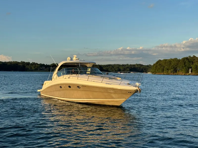 Slide: The Image of 2005 Sea Ray 420 Sundancer yacht cruising on a serene lake at sunset. - 3