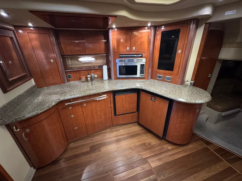 Slide: The Image of Luxurious 2005 Sea Ray 420 Sundancer yacht kitchen with wood cabinetry and granite countertops. - 32