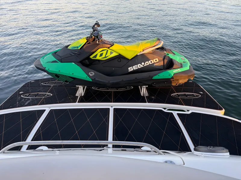Slide: The Image of Sea-Doo jet ski on 2005 Sea Ray 420 Sundancer boat, floating on calm water. - 37