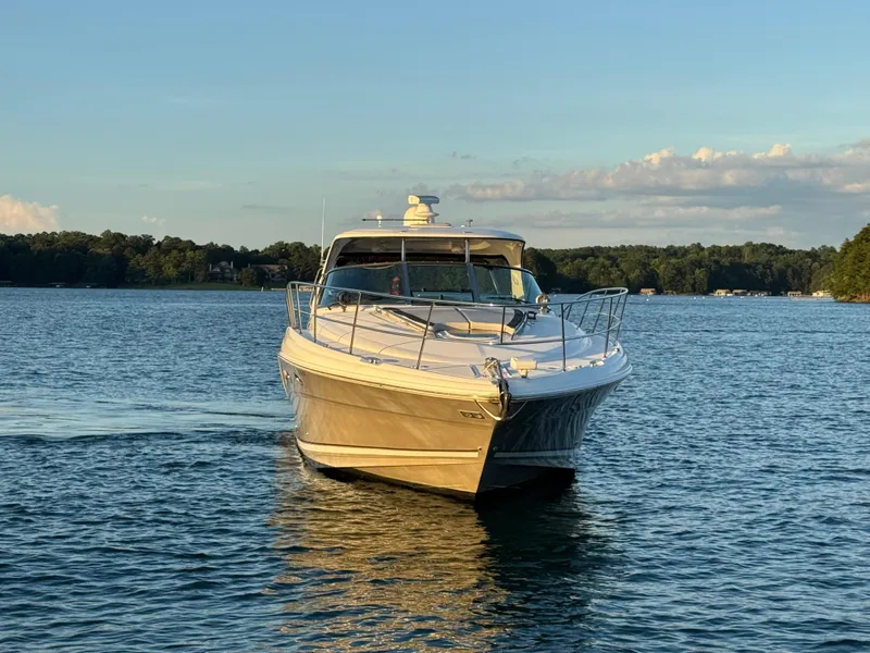 Slide: The Image of 2005 Sea Ray 420 Sundancer yacht cruising on a serene lake at sunset. - 4