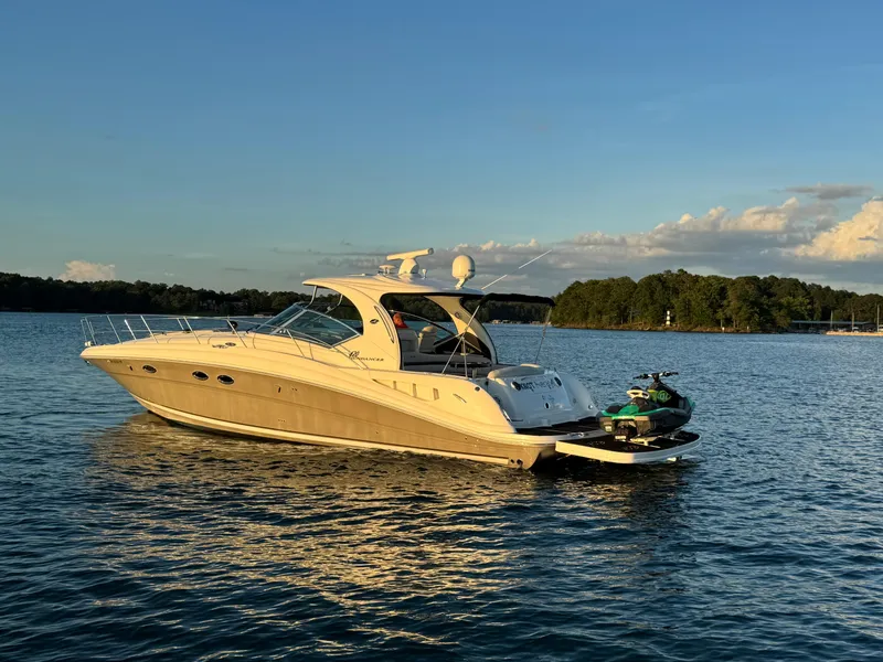 Slide: The Image of 2005 Sea Ray 420 Sundancer yacht on calm water at sunset with jet ski. - 8