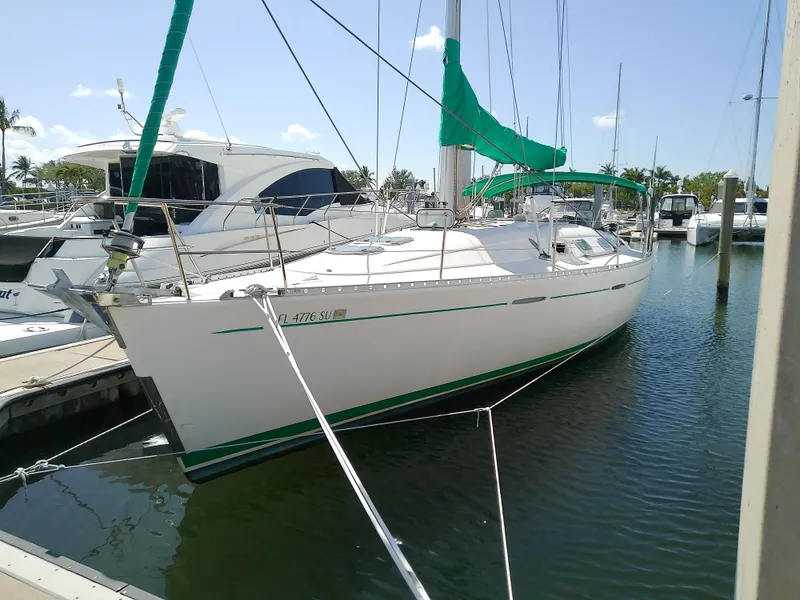 The Image of 1995 Beneteau First 42s7 sailboat docked in marina with green accents. - 0