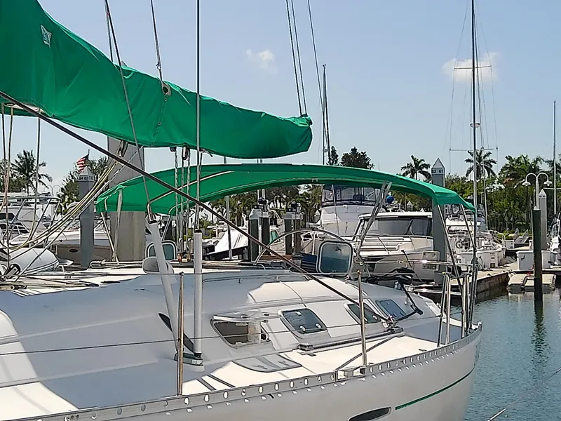 Slide: The Image of Sailboat Beneteau First 42s7, 1995 model, docked in a marina with green covers. - 2