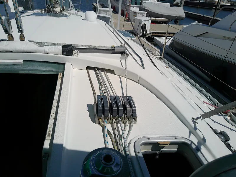 Slide: The Image of 1995 Beneteau First 42s7 sailboat deck with rigging and winch in marina. - 26