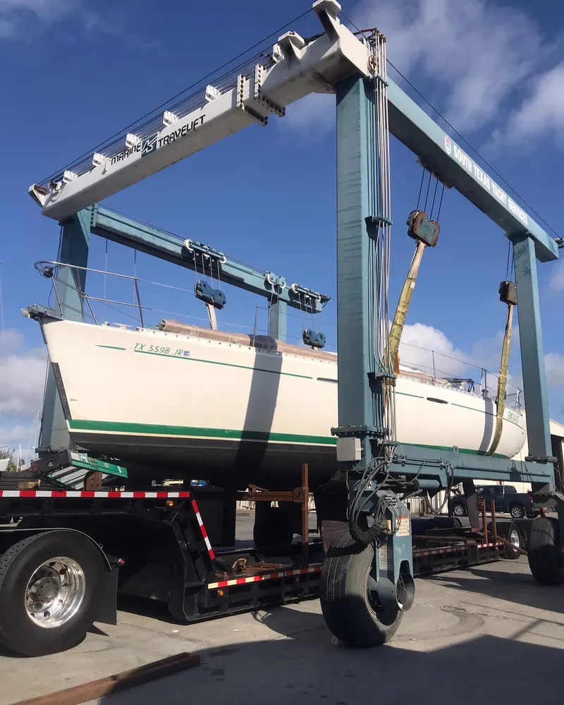 Slide: The Image of 1995 Beneteau First 42s7 sailboat on a transport lift under blue sky. - 34