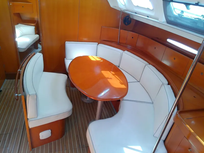 Slide: The Image of Interior of 1995 Beneteau First 42s7 yacht with elegant wood finish and white seating. - 38