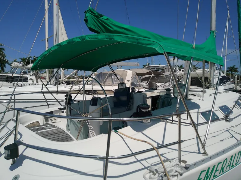 Slide: The Image of Sailboat Beneteau First 42s7, 1995 model, docked with green canopy, sunny marina setting. - 4