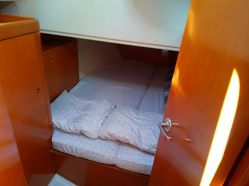 Slide: The Image of Cozy cabin interior of 1995 Beneteau First 42s7 sailboat with wooden finish and bedding. - 46