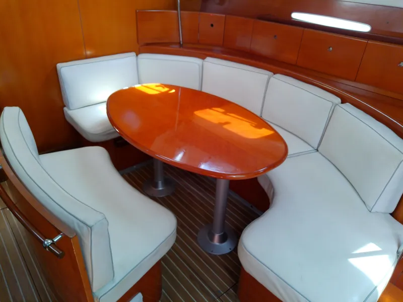 Slide: The Image of Luxurious interior of 1995 Beneteau First 42s7 yacht with elegant seating and wooden table. - 50