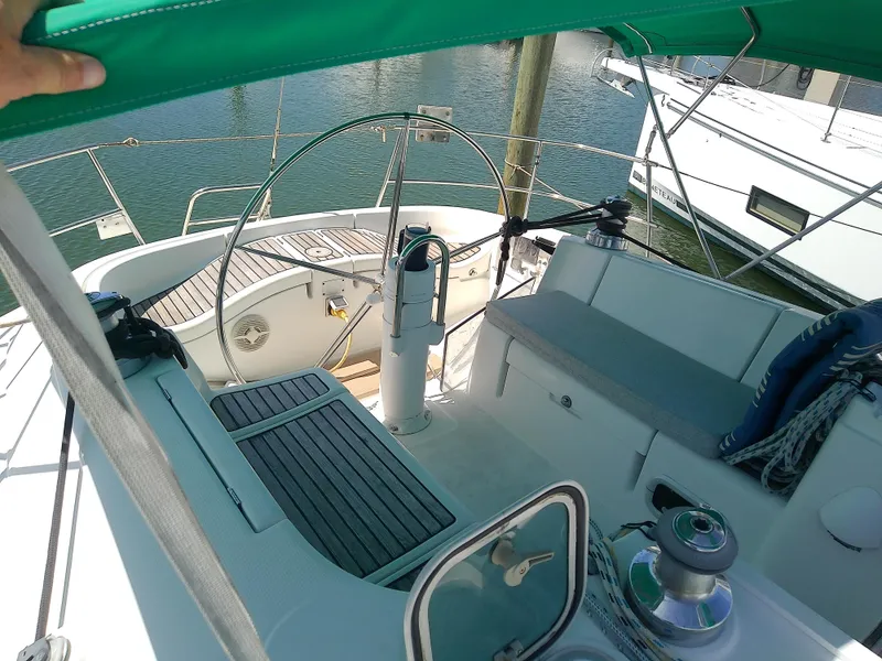 Slide: The Image of Cockpit of 1995 Beneteau First 42s7 sailboat with green canopy and wooden deck. - 8