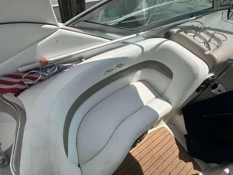 Slide: The Image of 2006 Sea Ray 320 Sundancer boat interior with white seating and wooden flooring. - 10