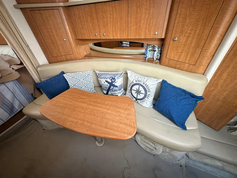 Slide: The Image of Interior of 2006 Sea Ray 320 Sundancer with cushioned seating and decorative pillows. - 13